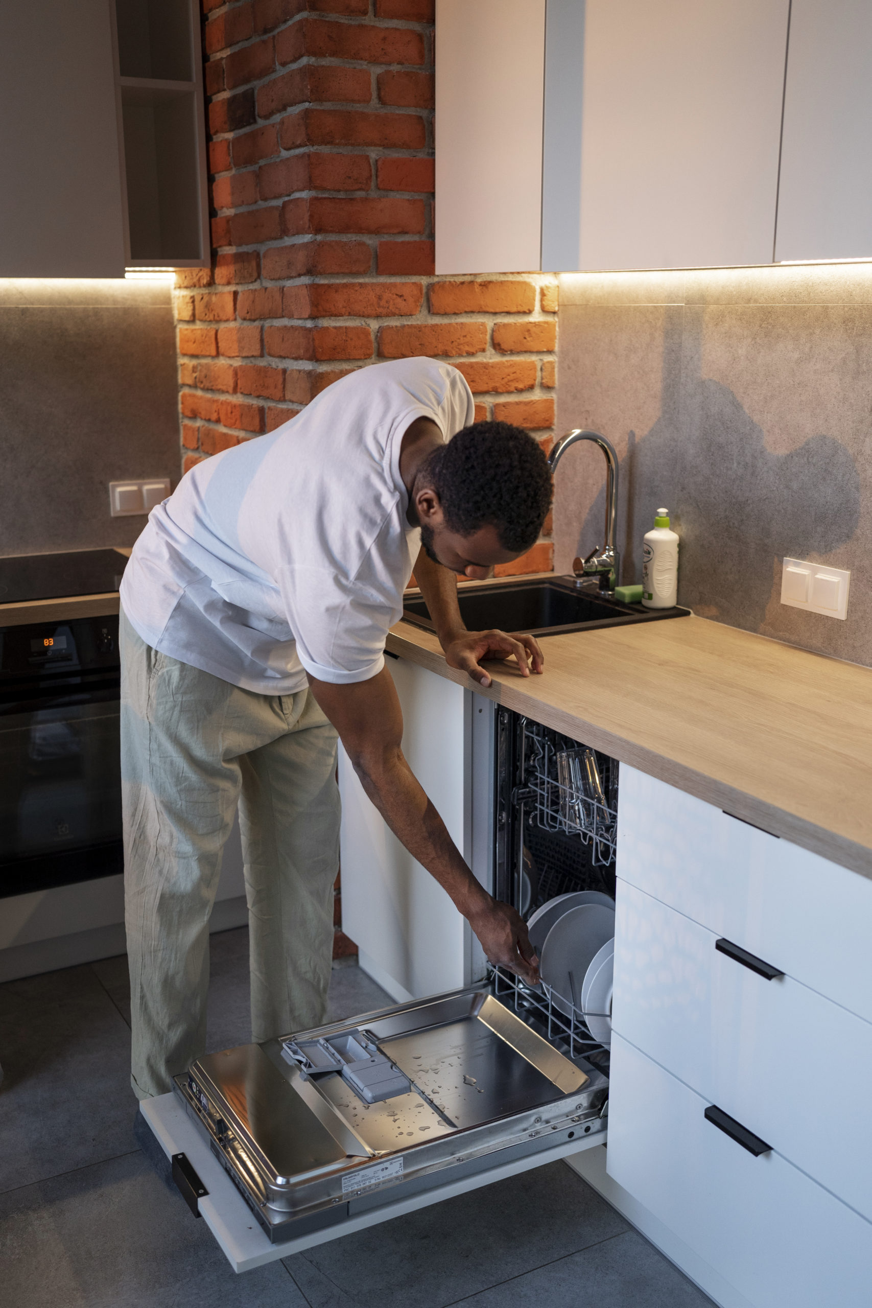 side-view-man-loading-dishwasher